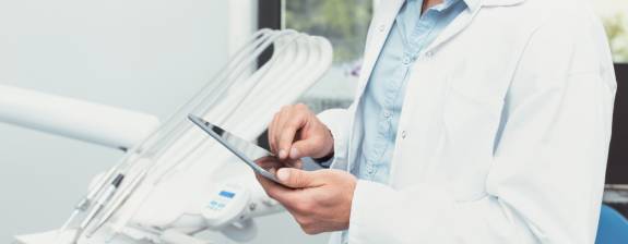 Arzt prüft Daten auf einem Tablet