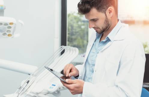 Arzt prüft Daten auf einem Tablet