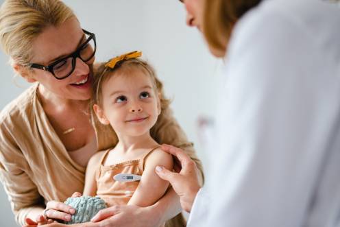 Ärztin spricht mit Kind und Mutter