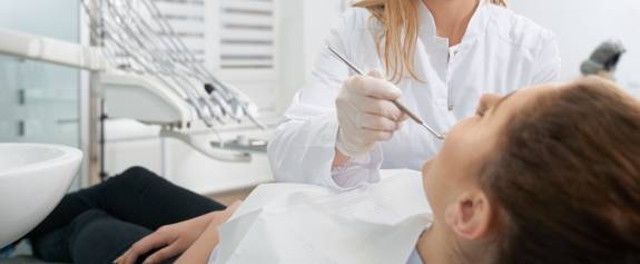Zahnärztin bahandelt Patient